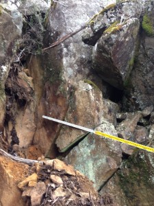 The 2.5m wide gap left by the fallen boulder, between two other similarly leaning boulders, at 1,000m elevation.